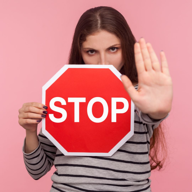 Dívka s gestem stop signalizující boj proti nedokonalostem pleti a lesklé pokožce