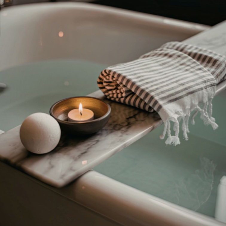 vana plná teplé vody s aromaterapeutickou vůní při svíčkách