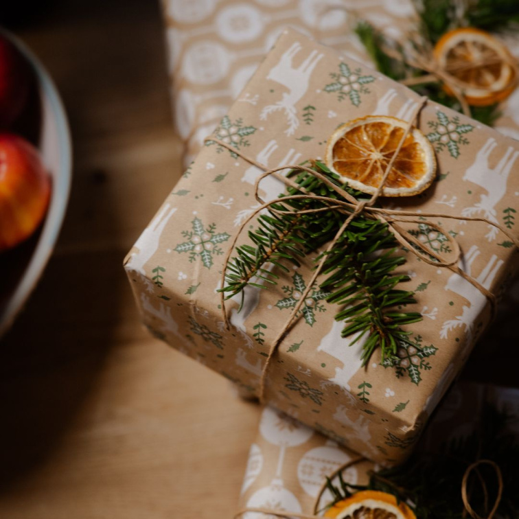 vánočně zabalené dárky, s plátkem pomeranče a jehličnatou větvičkou
