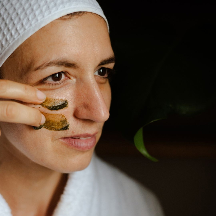 žena aplikující si na obličej zklidňující a regenerační pleťovou masku