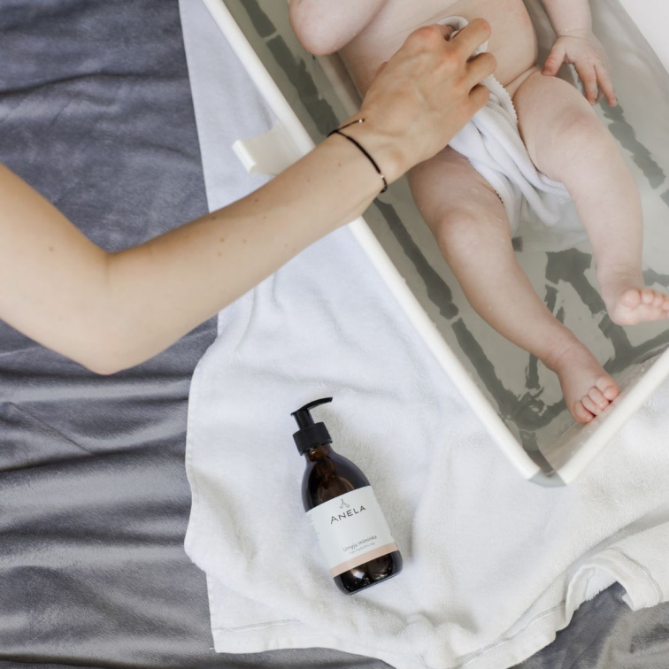Koupání miminka ve vaničce s využitím šetrného hydrofilního mycího oleje Umyju miminka od značky Anela.