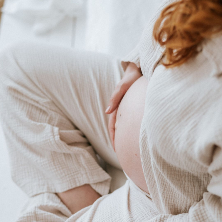 žena hladící si těhotenské bříško