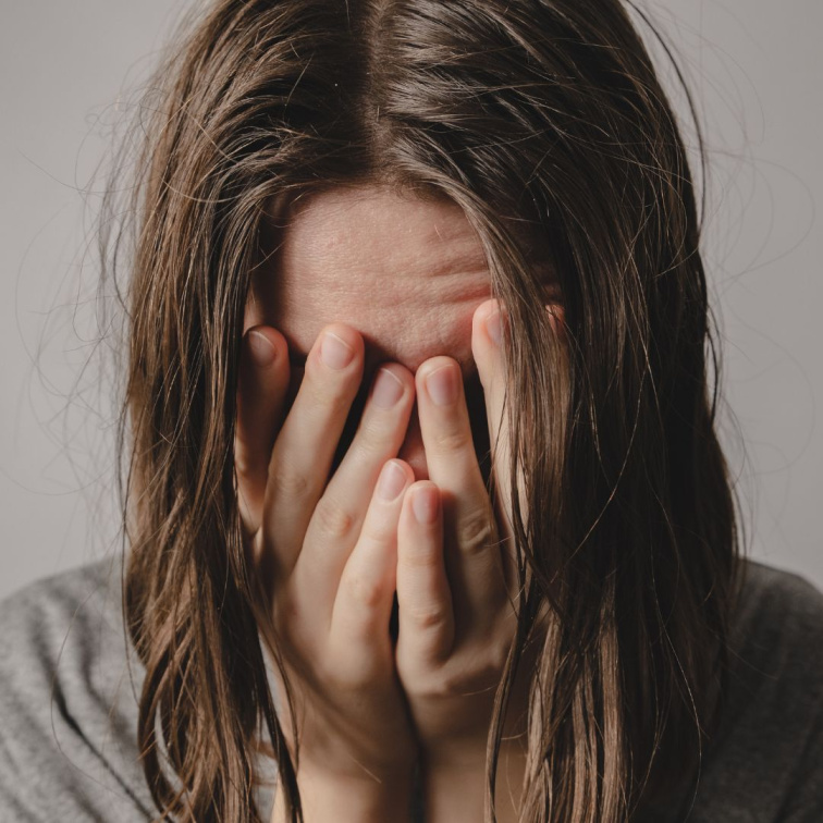 ustaraná žena s obličejem v dlaních