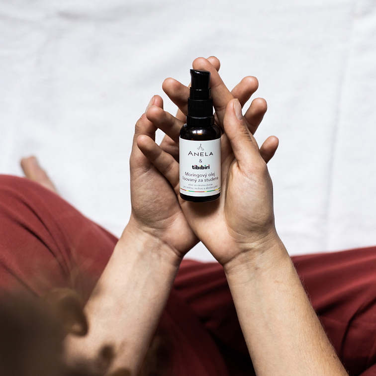žena držící v rukou moringový olej