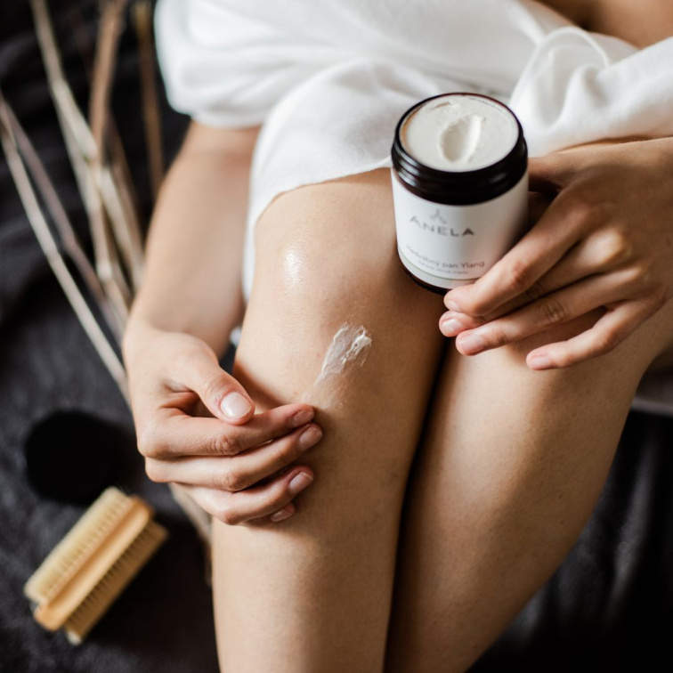 žena mazající si nohu šlehaným máslem