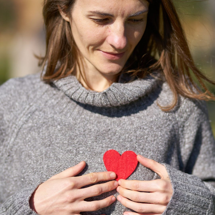 žena dívajíc se srdcem
