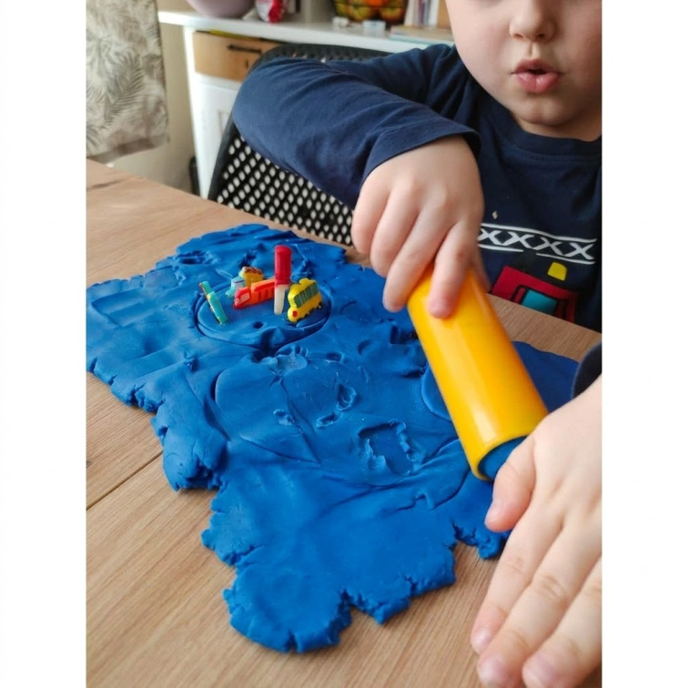 Malý chlapeček má v ruce váleček a válí měkoučkou modelínu pro nejmenší od české značky Mámy v rejži.