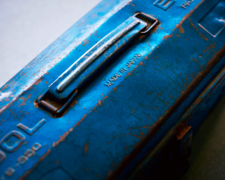 Detail modrého kovového boxu Toyo Steel s patinou a nápisem Made in Japan