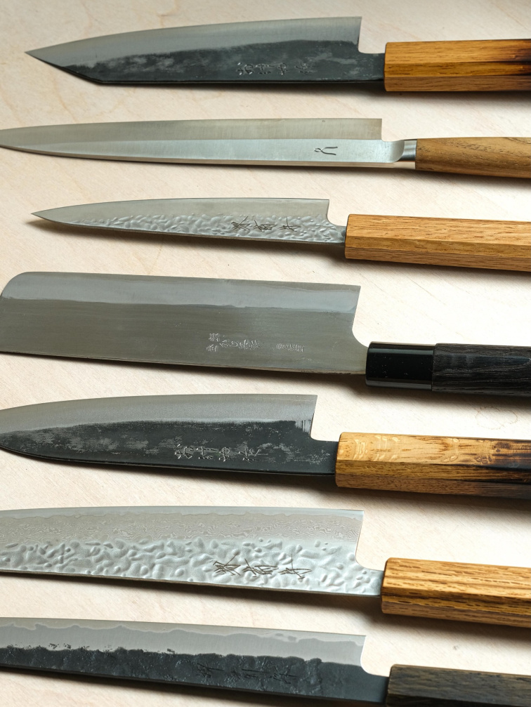 Různé typy kuchyňských nožů (gyuto, santoku, petty) pro sestavení vlastní sady