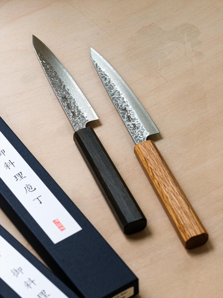 Kuchyňské nože položené na dřevěné desce v přirozeném světle